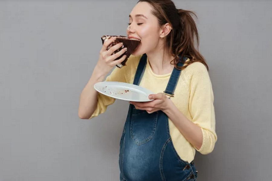 Femme enceinte mange un gateau